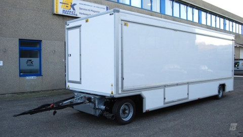 Zijaanzicht van een aanhangwagen voor drogisterijartikelen met gesloten luifel