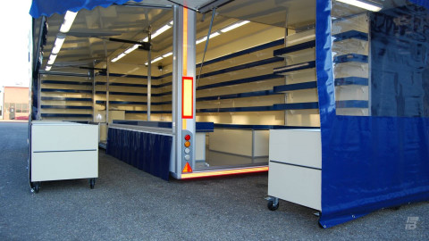 Zijaanzicht van een aanhangwagen voor drogisterijartikelen met geopende luifel