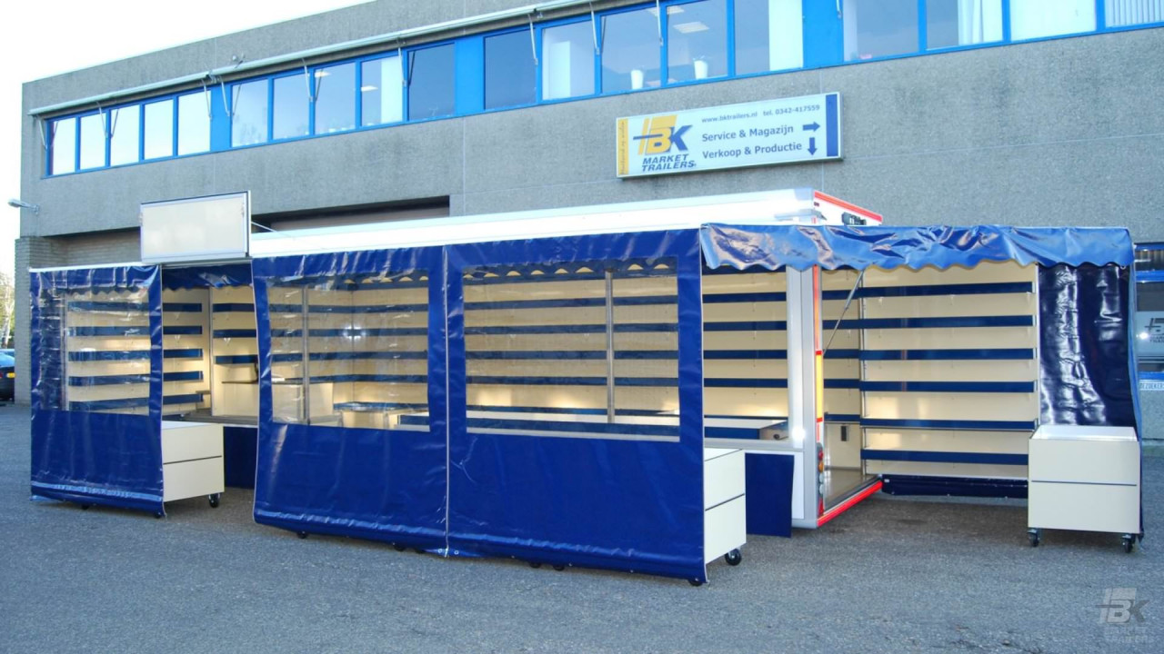 Zijaanzicht van een aanhangwagen voor drogisterijartikelen met geopende luifel
