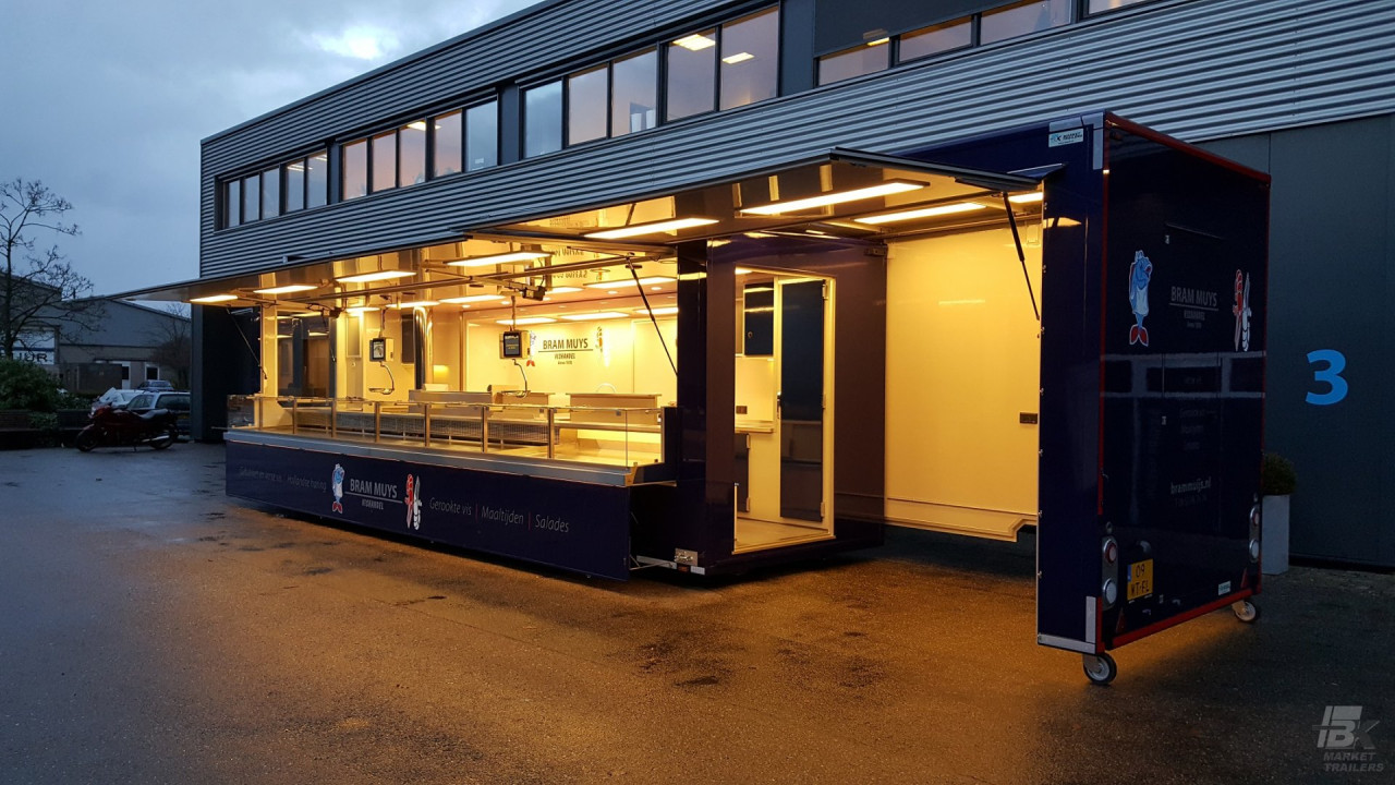 Zijaanzicht van een aanhangwagen voor vis met geopende luifel en verlichting