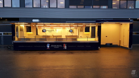 Zijaanzicht van een aanhangwagen voor vis met geopende luifel en verlichting