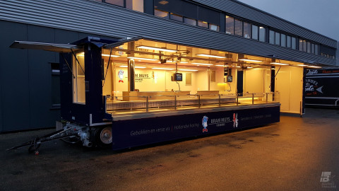 Zijaanzicht van een aanhangwagen voor vis met geopende luifel en verlichting