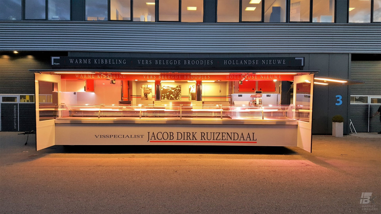 Zijaanzicht van een aanhangwagen voor vis met geopende luifel en zijborden