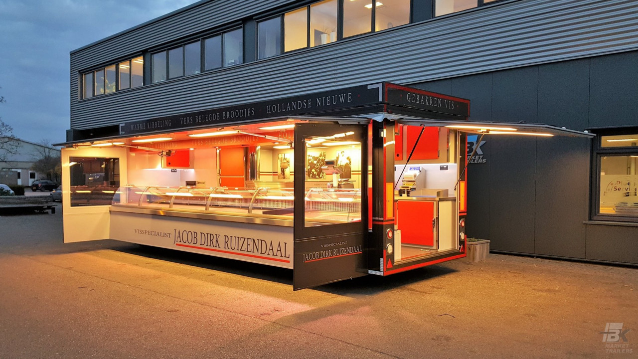 Zijaanzicht van een aanhangwagen voor vis met geopende luifel en zijborden