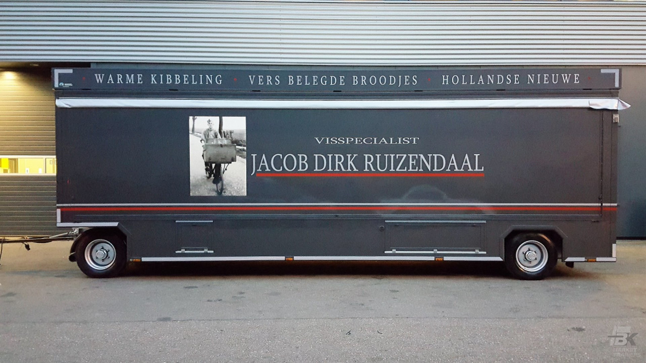 Zijaanzicht van een aanhangwagen voor vis met gesloten luifel en zijborden