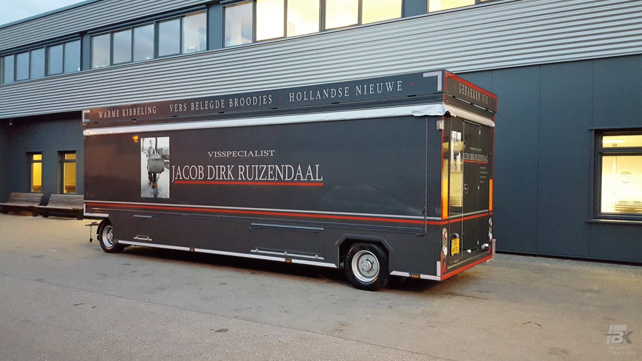 Zijaanzicht van een aanhangwagen voor vis met gesloten luifel en zijborden