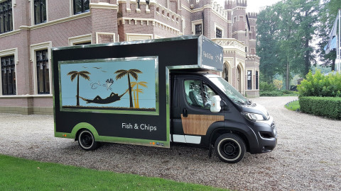 Zijaanzicht van een verkoopwagen voor vis en patat met gesloten luifel