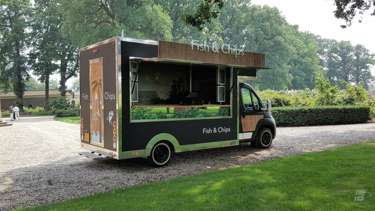 Zijaanzicht van een verkoopwagen voor vis en patat met geopende luifel