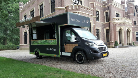 Zijaanzicht van een verkoopwagen voor vis en patat met gesloten luifel