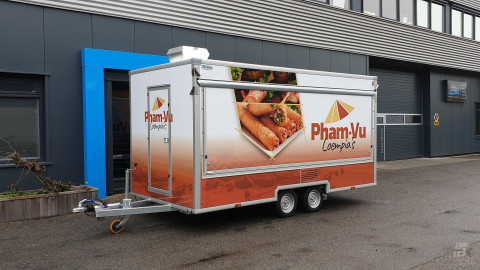 Zijaanzicht van een aanhangwagen voor loempia's met gesloten luifel