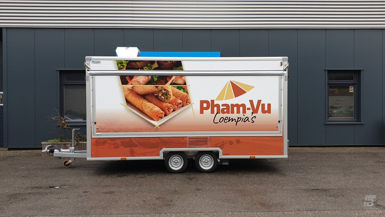 Zijaanzicht van een aanhangwagen voor loempia's met gesloten luifel