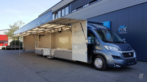 Zijaanzicht van een verkoopwagen voor mode met geopende luifel