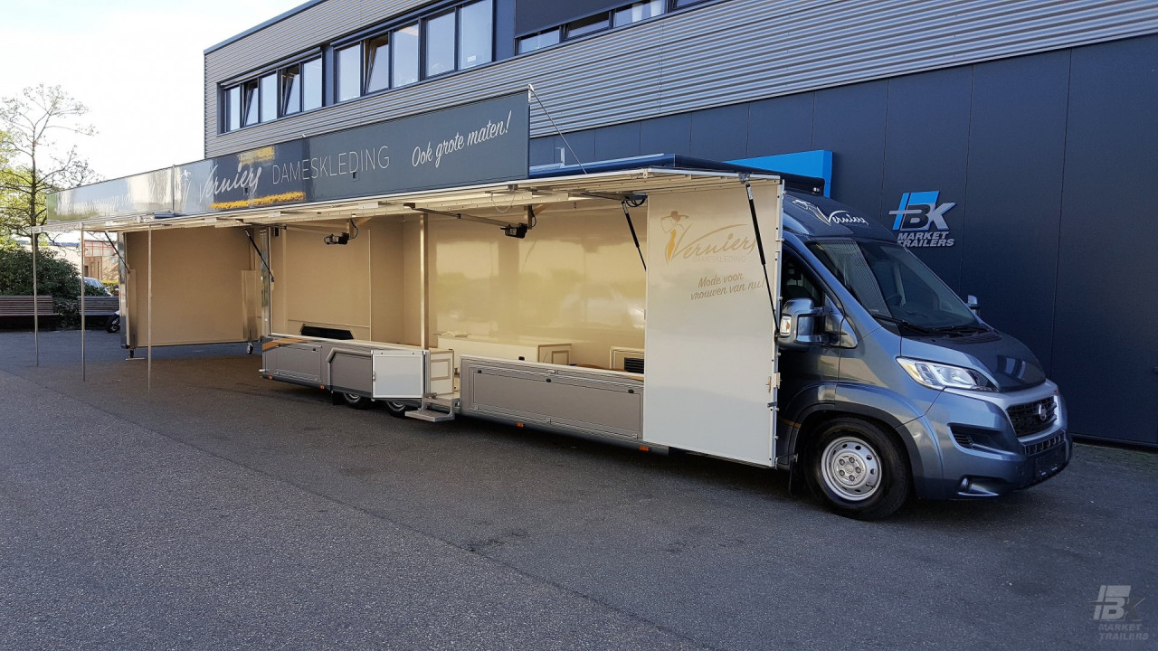Zijaanzicht van een verkoopwagen voor mode met geopende luifel