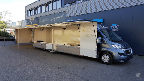 Zijaanzicht van een verkoopwagen voor mode met geopende luifel