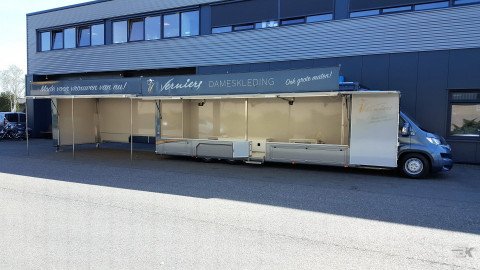 Zijaanzicht van een verkoopwagen voor mode met geopende luifel