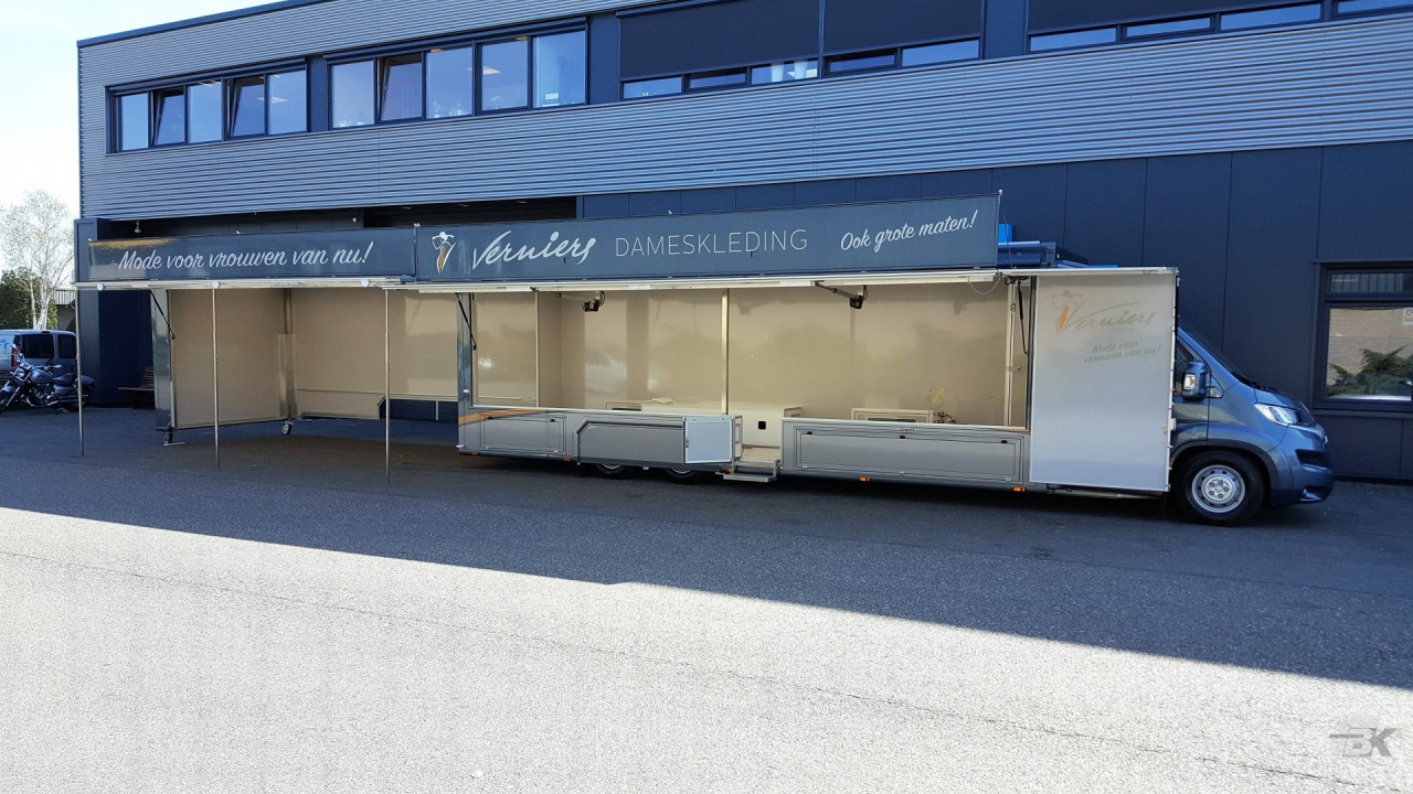 Zijaanzicht van een verkoopwagen voor mode met geopende luifel