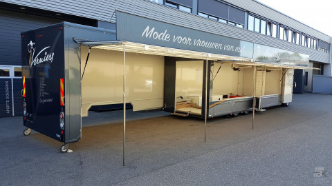 Zijaanzicht van een verkoopwagen voor mode met geopende luifel