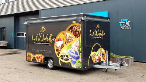 Zijaanzicht van een aanhangwagen voor wafels met gesloten luifel