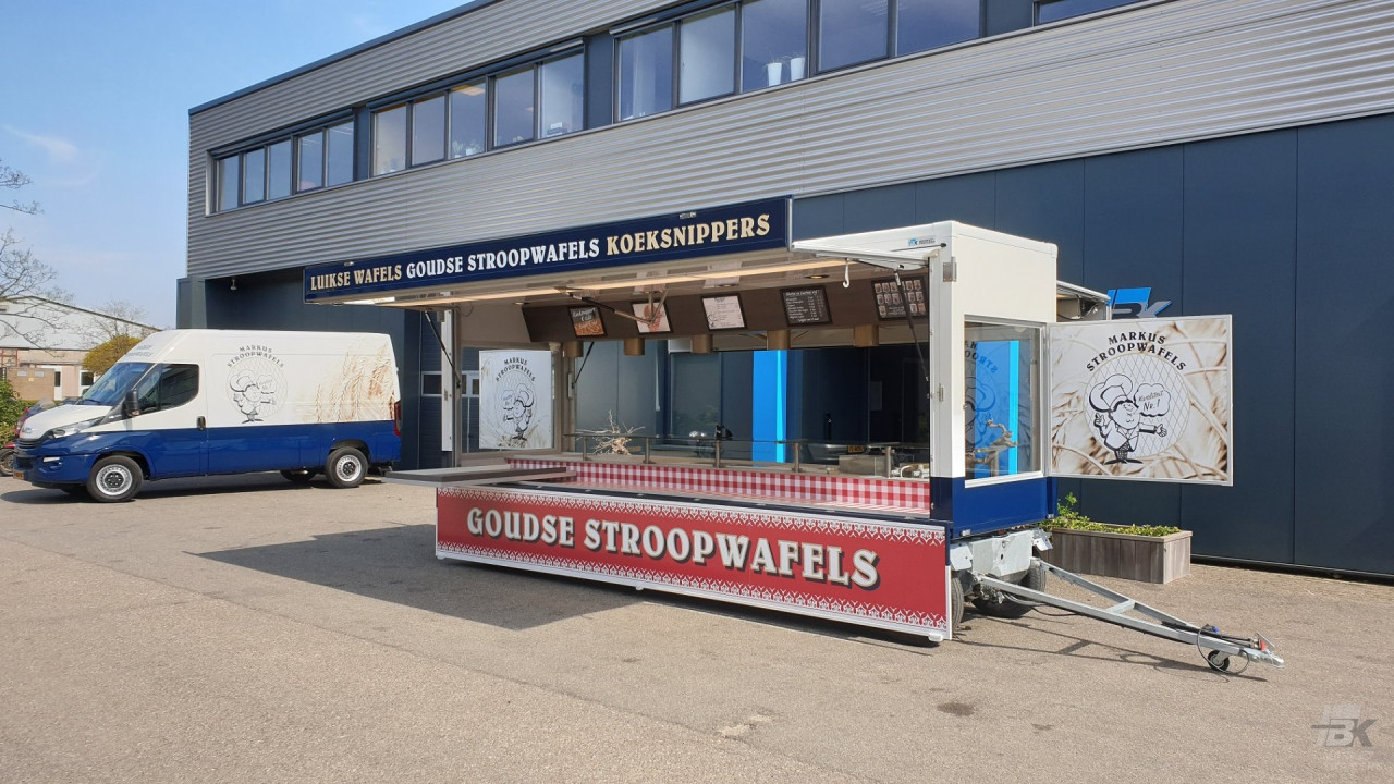 Zijaanzicht van een aanhangwagen voor stroopwafels met geopende luifel
