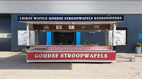 Zijaanzicht van een aanhangwagen voor stroopwafels met geopende luifel