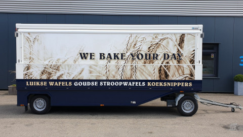 Zijaanzicht van een aanhangwagen voor stroopwafels met gesloten luifel
