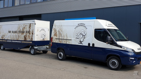 Zijaanzicht van een Iveco bus met aanhangwagen voor stroopwafels