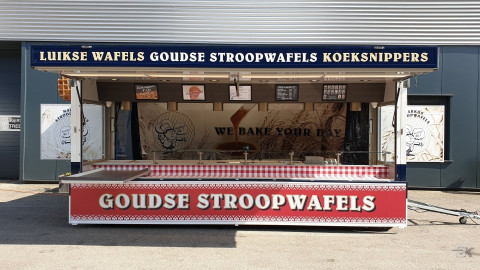 Zijaanzicht van een aanhangwagen voor stroopwafels met geopende luifel