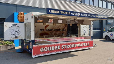 Zijaanzicht van een aanhangwagen voor stroopwafels met geopende luifel