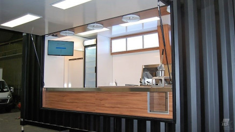 Zijaanzicht van een container kiosk met geopende luifel