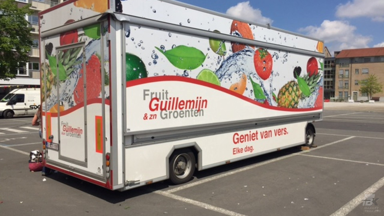 Zijaanzicht van een aanhangwagen voor groente en fruit met gesloten luifel