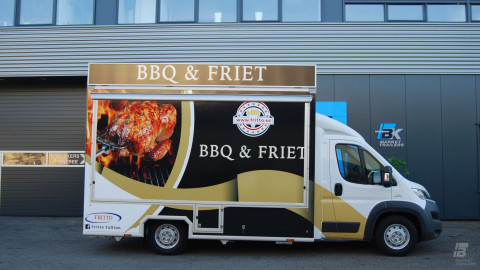 Zijaanzicht van een verkoopwagen voor gegrilde kip met gesloten luifel