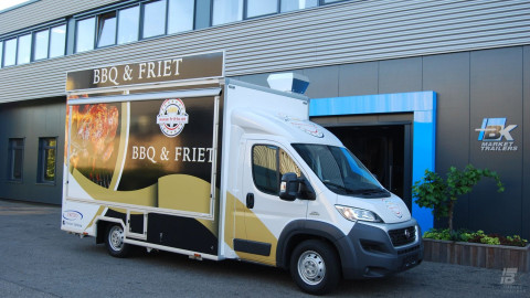Zijaanzicht van een verkoopwagen voor gegrilde kip met gesloten luifel