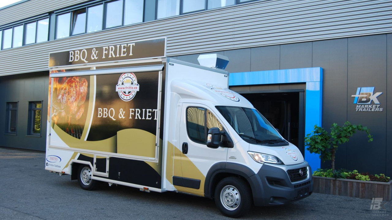 Zijaanzicht van een verkoopwagen voor gegrilde kip met gesloten luifel