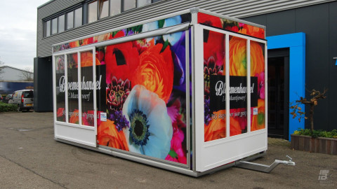 Zijaanzicht van een aanhangwagen voor bloemen met gesloten luifel