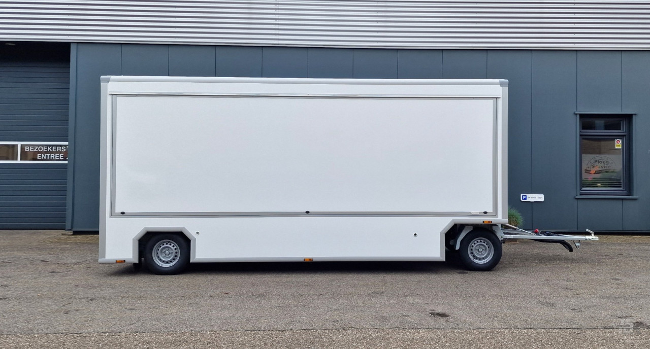 Zijaanzicht van een aanhangwagen voor diverse branches met gesloten luifel