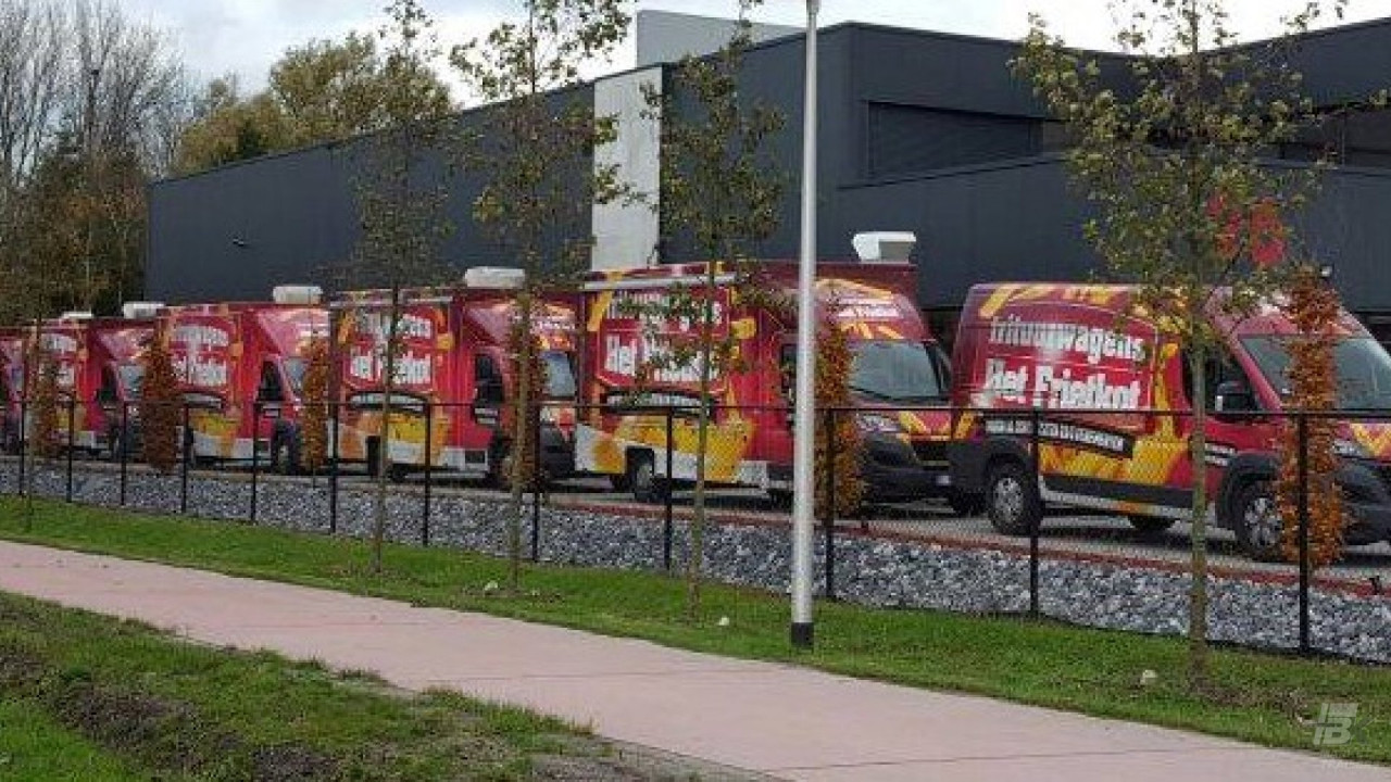 Zijaanzicht van vijf verkoopwagens voor patat met gesloten luifels