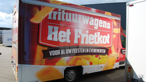 Zijaanzicht van een verkoopwagen voor patat met gesloten luifel