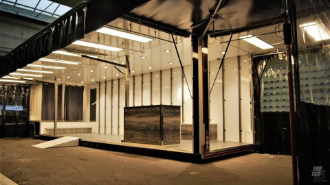 Zijaanzicht van een aanhangwagen voor kleding met geopende luifel