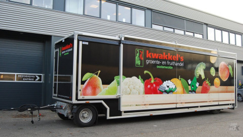 Zijaanzicht van een aanhangwagen voor groente en fruit met gesloten luifel