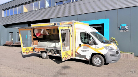 Zijaanzicht van een verkoopwagen voor koeken met geopende luifel