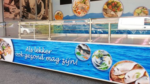 Detail van reclamebestickering aan de buitenkant van een uitschuifbare aanhangwagen voor vis