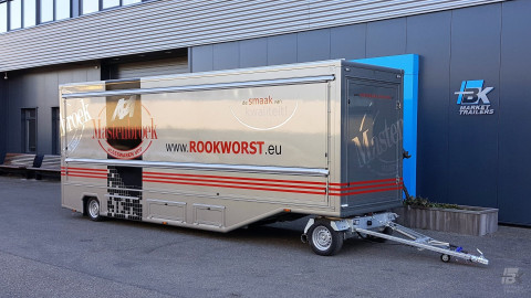 Zijaanzicht van een aanhangwagen voor poelierswaren met gesloten luifel