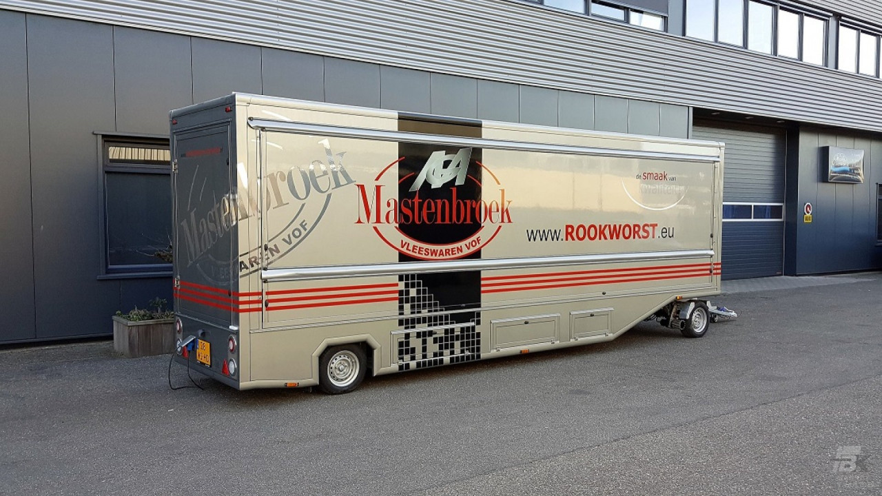 Zijaanzicht van een aanhangwagen voor poelierswaren met gesloten luifel