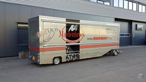 Zijaanzicht van een aanhangwagen voor poelierswaren met gesloten luifel