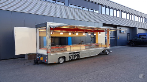 Zijaanzicht van een aanhangwagen voor poelierswaren met geopende luifel