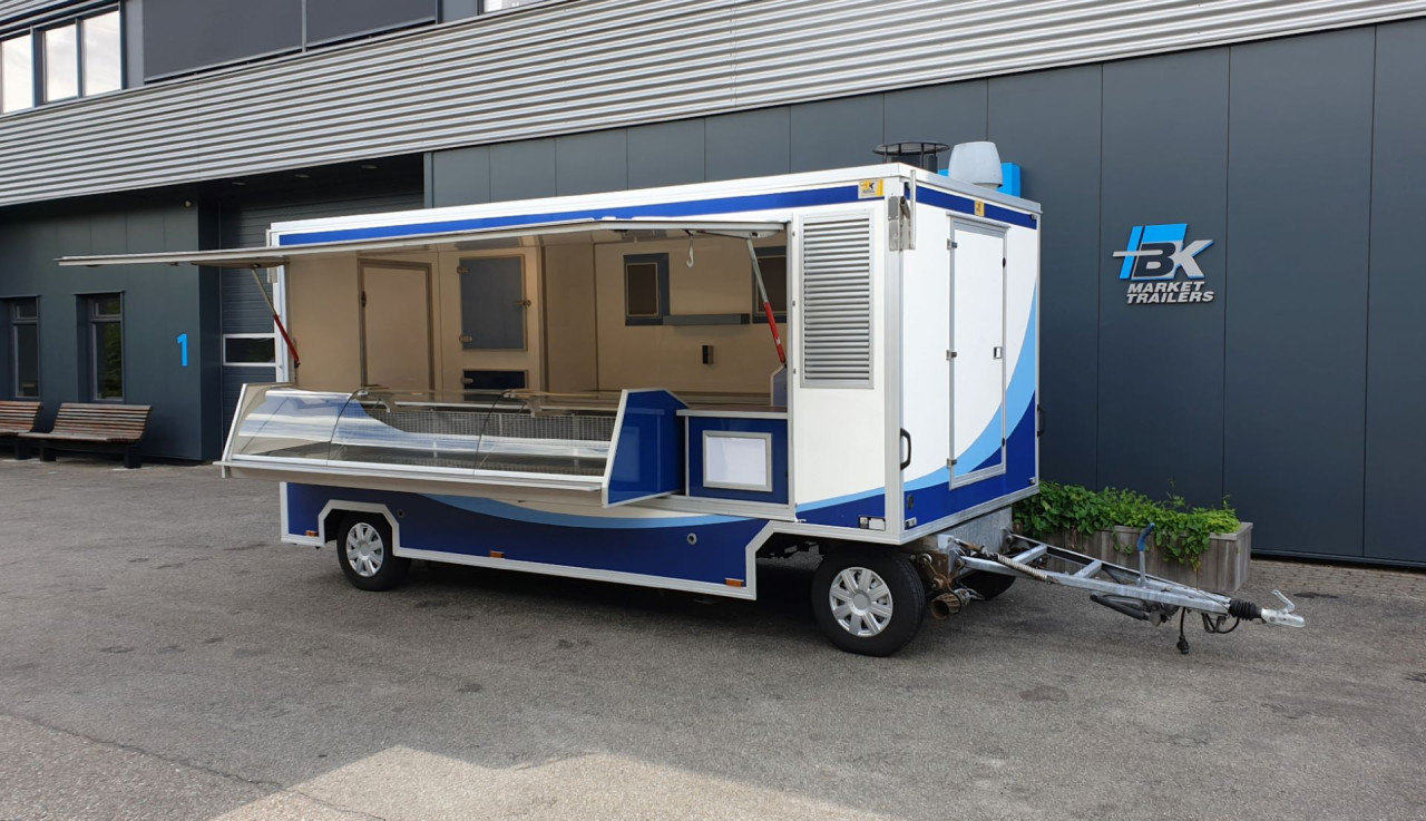 Zijaanzicht van een aanhangwagen voor diverse branches met geopende luifel