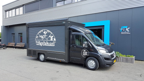 Zijaanzicht van een verkoopwagen voor kaas met gesloten luifel