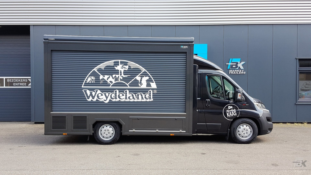 Zijaanzicht van een verkoopwagen voor kaas met gesloten luifel