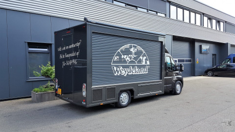 Zijaanzicht van een verkoopwagen voor kaas met gesloten luifel