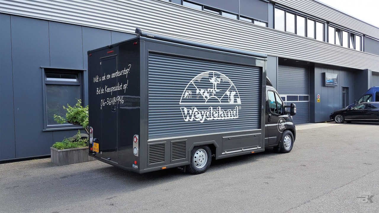 Zijaanzicht van een verkoopwagen voor kaas met gesloten luifel